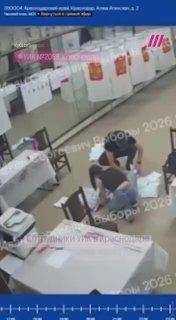 Сотрудники избирательной комиссии в Краснодаре вскрывают сейф-пакет и опускают бюллетени под камерами видеонаблюдения.